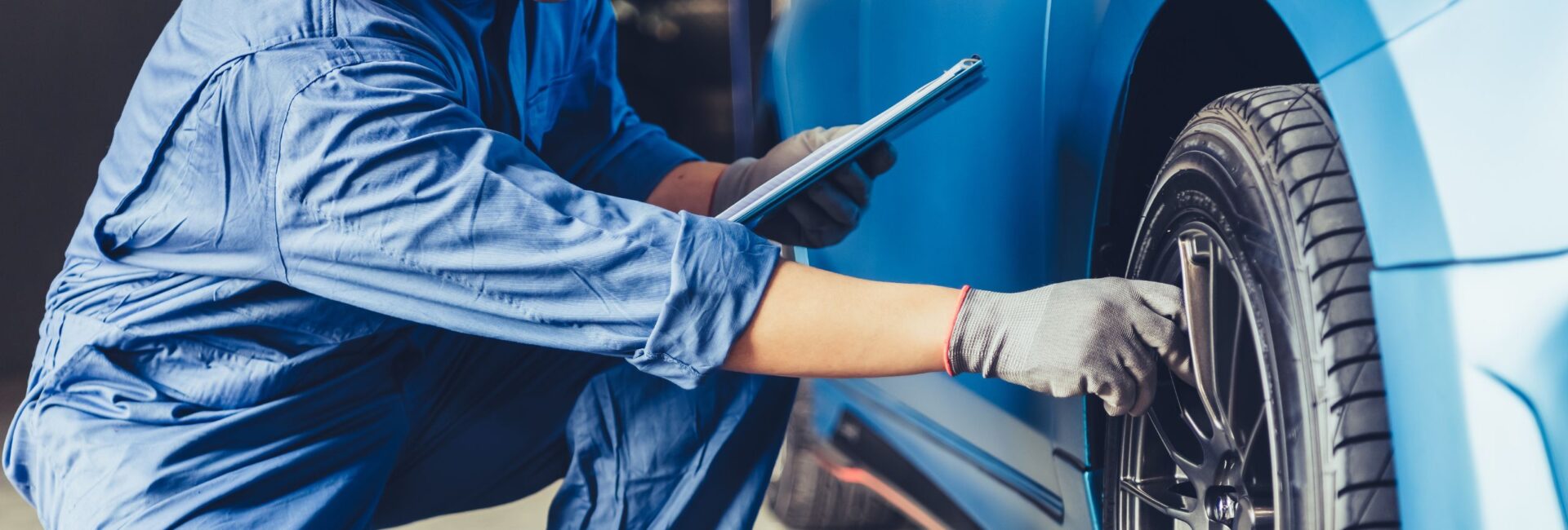 Person Checking Tire on Vehicle