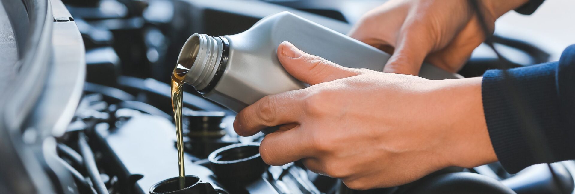 Person Pouring Oil into Vehicle